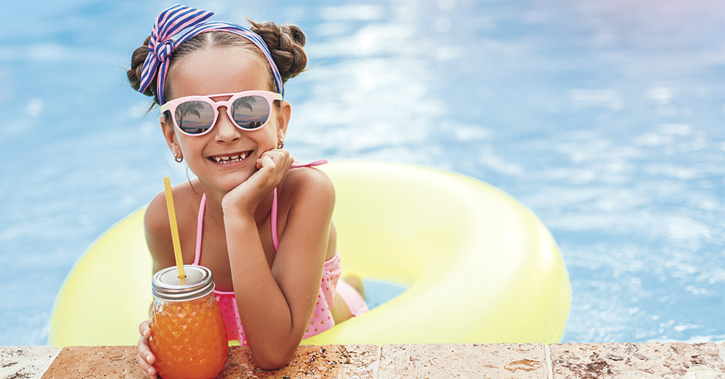 Girl with a drink poolside