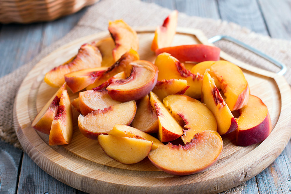 Wooden tray of peaches.