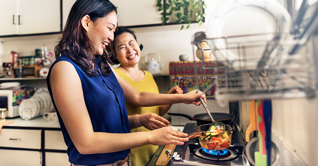 Mother and daughter cooking a vegan meal together in the kitchen.