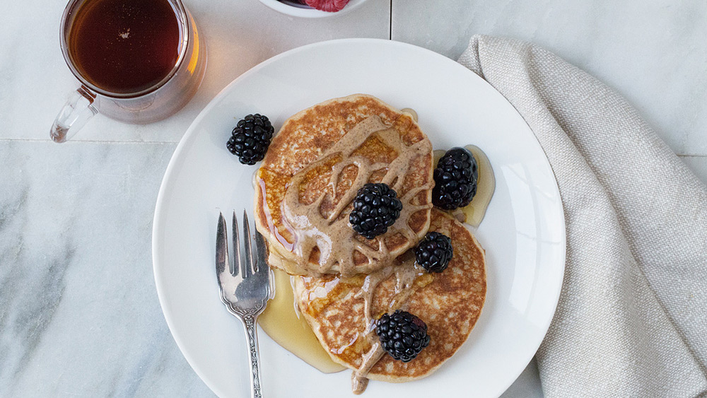 Vegan pancakes served with maple syrups and berries.