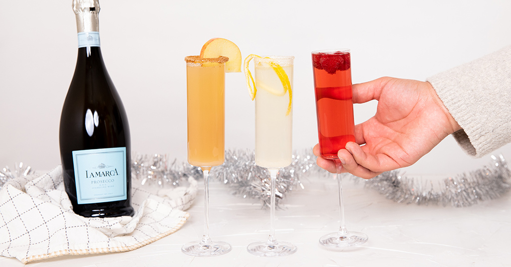 Festive sparkling wine cocktails lined up in a row.