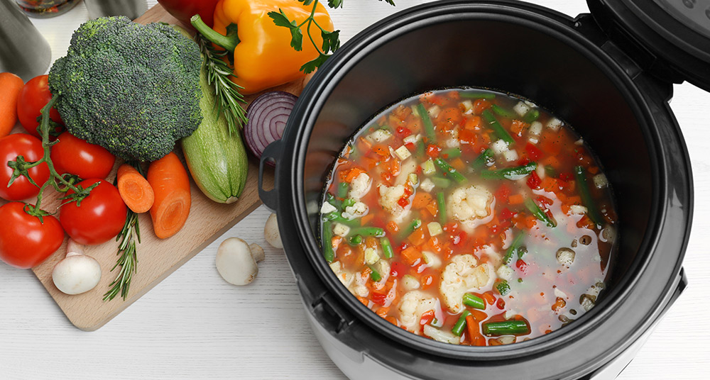 Healthy vegetable soup cooking in slow cooker.