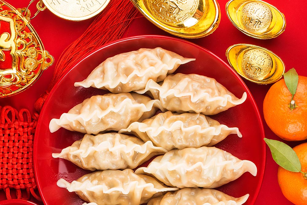 Dumplings and other foods laid out on a table for lunar new year.
