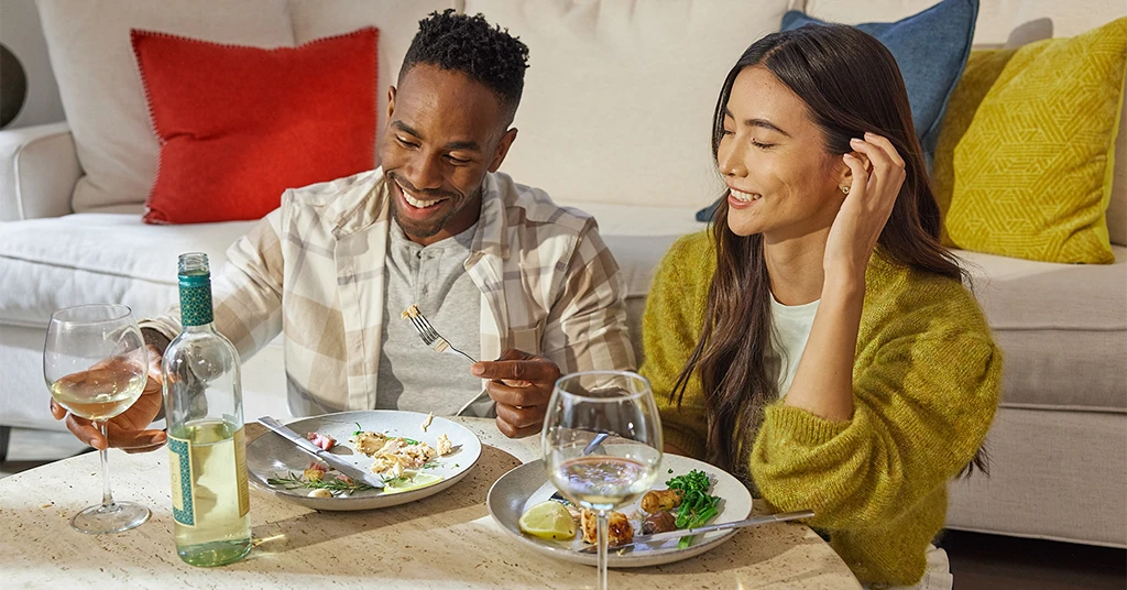 Couple eating together in living room