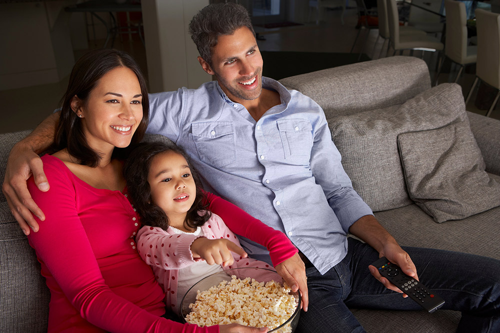 Family watching a movie together.