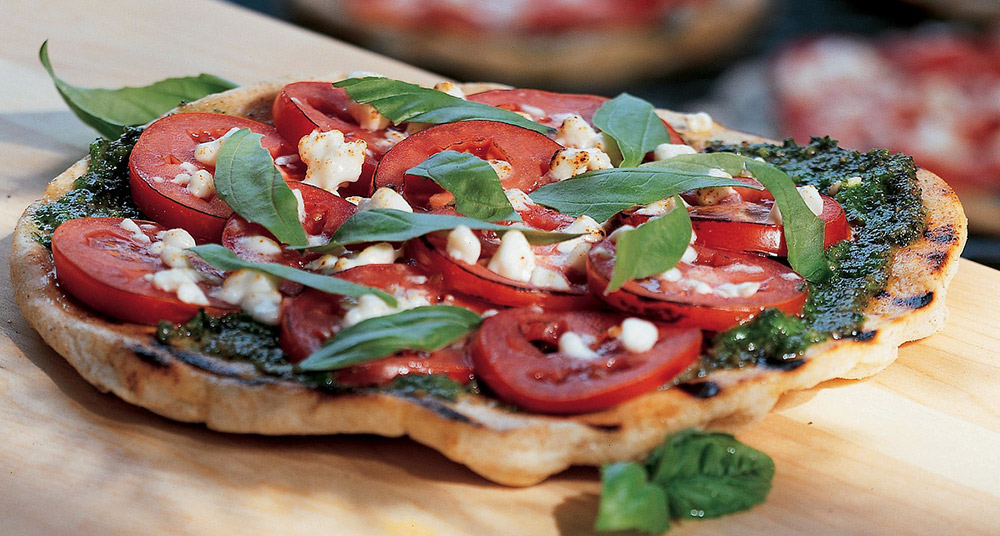 Grilled pizza with pesto, tomatoes, and feta.