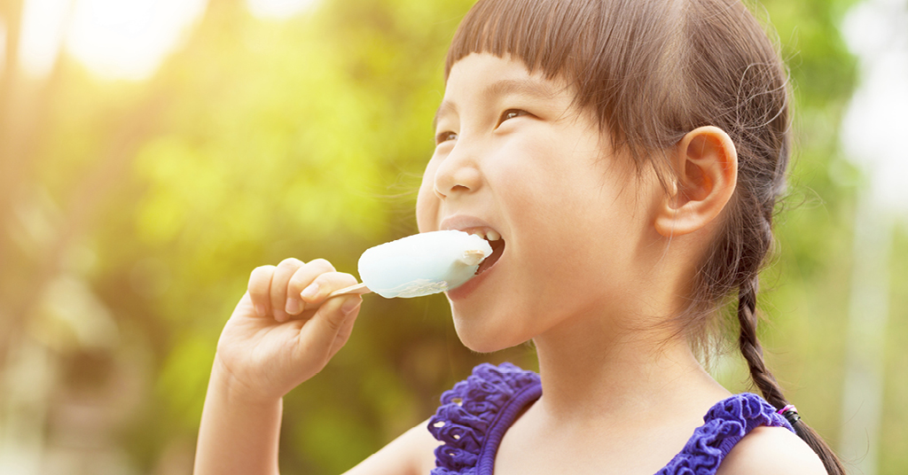Little girl eating a popsicle