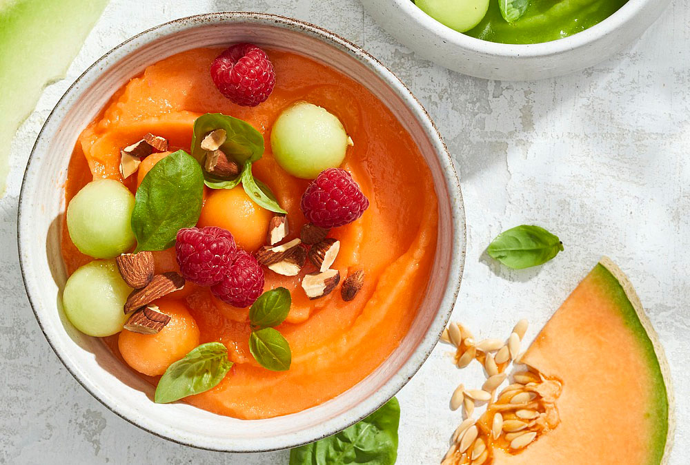 Cantaloupe smoothie bowl with raspberries and almonds.