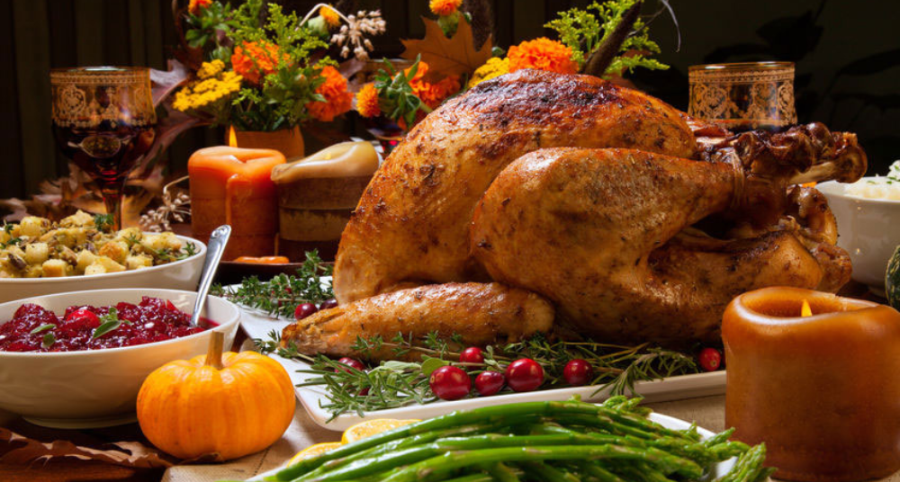 Thanksgiving table with cooked turkey and side dishes. 