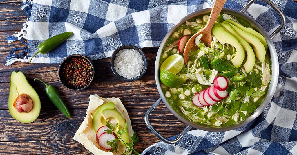 Pozole Verde in a bowl garnished with avocado
