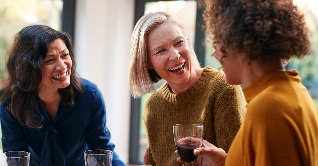 Gal pals gathering together and sharing wine to celebrate friendship on Galentine's Day.