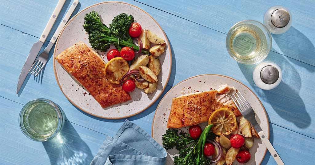 Salmon steamed and seasoned with spices, served with fresh vegetables and lemon.