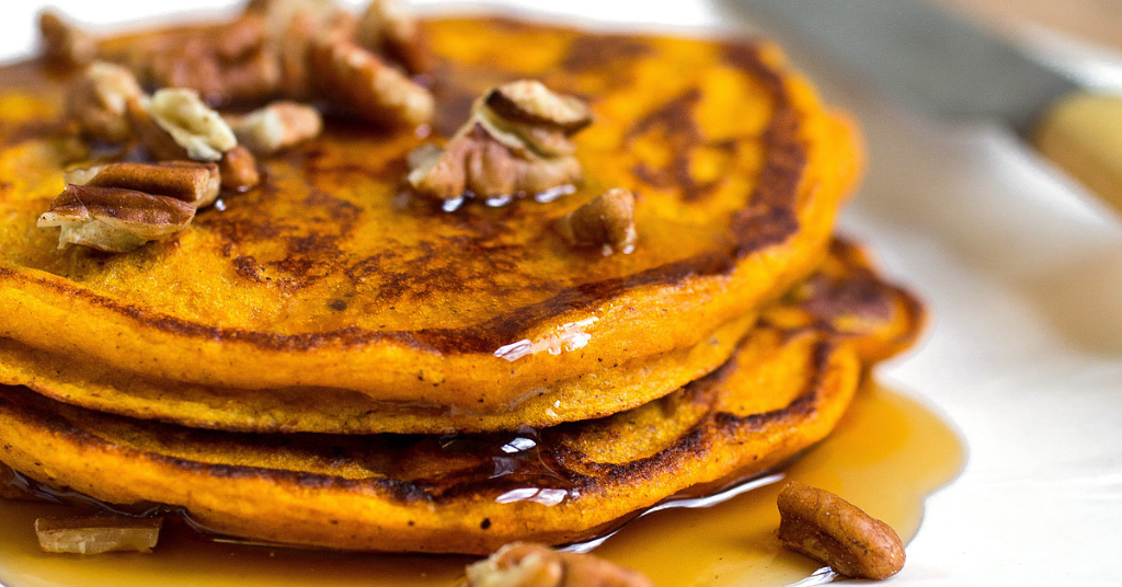 Pumpkin pancakes topped with chopped pecans. 