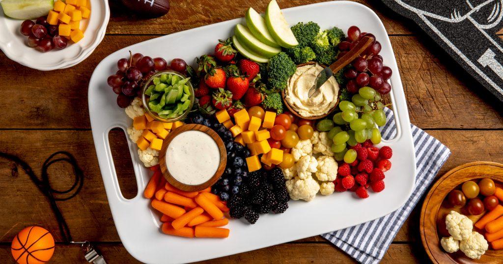 Tray of vegetables and cheese surrounded by sport accessories